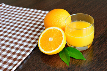 orange juice in drinking glass with fresh orange fruit on wooden background