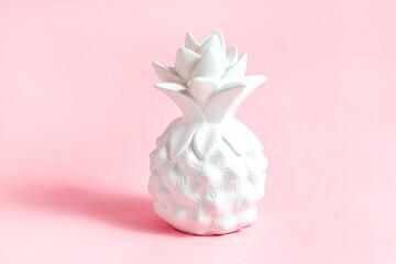 White pineapple tropical fruit on light pastel pink background.