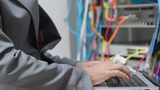Male administrator it engineer conducts maintenance work in secure server room of cyberspace