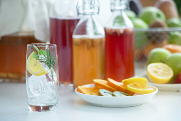 Homemade fermented raw Kombucha tea, healthy natural probiotic flavored drink, glass of Kombucha drink with slice of lemon against white background