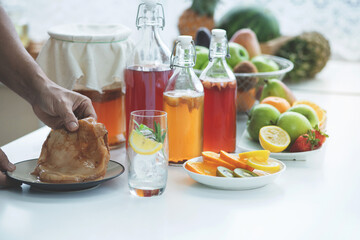 Man holding the Scoby or fungus over plate, Scoby tea mushroom to start the fermentation process to make Kombucha, dietetic organic superfood healthy fermented tea