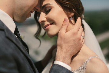 Beautiful groom and bride embracing on roof top building with city background