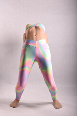 A beautiful slender gymnast in a stretch in a tracksuit does sports or yoga in an attractive pose