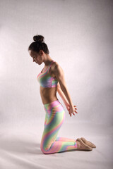 Obraz premium A beautiful slender gymnast in a stretch in a tracksuit does sports or yoga in an attractive pose