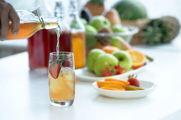 Man pouring kombucha from bottle to made Kombucha cocktail, strawberry and rosemary, strawberry flavored Kombucha healthy drink, Kombucha drink organic probiotic beverage