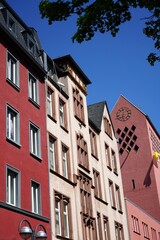 Sanierte Altbaufassaden in Naturfarben und Pastelltönen und Kirchturm der Kirche St. Joseph vor...
