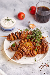 Crispy tornado potatoes. Potato chips on skewers, roasted with thyme and spices. Delicious snack served with sauce. Fast food.