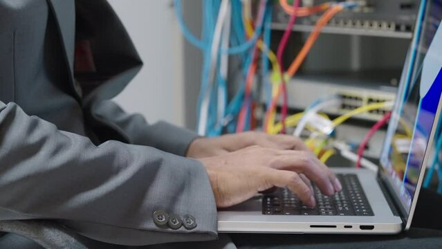 Male administrator it engineer conducts maintenance work in secure server room of cyberspace