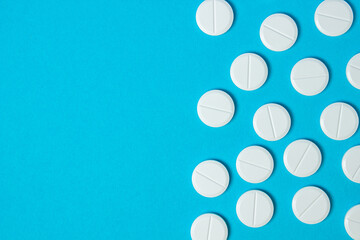 White pills on a blue background. Prevention and treatment with pills. Vitamin tablets