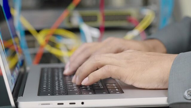 Male administrator it engineer conducts maintenance work in secure server room of cyberspace