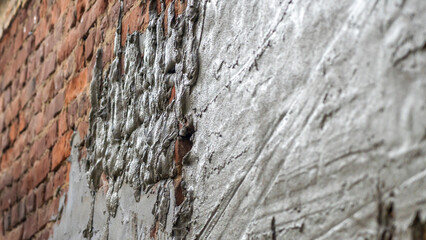 Plastering cement at wall for renovation house. Plasterer smoothing plaster on wall. Putty brick wall background