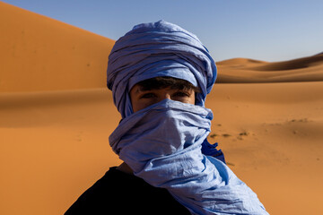 Joven con turbante azul en el desierto