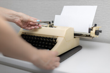 female hand shifts the typewriter carriage by pressing the lever - obrazy, fototapety, plakaty
