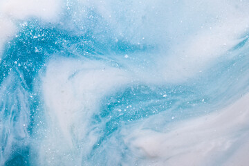 Liquid art gel blue gradient background with glitter. Slime toy. Abstract blue white surface. 