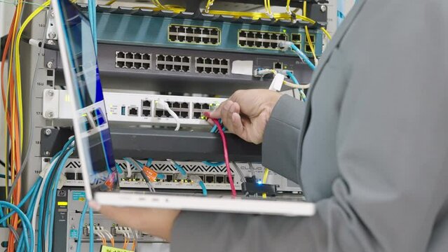Male administrator it engineer conducts maintenance work in secure server room of cyberspace
