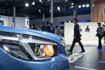 車の展示会・モーターショー　イベント会場を歩く人々・ビジネスマン　Car and blurred people in motor show exhibition, car dealership showroom