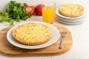 Cheese quiche, a pie on a wooden board, on a table