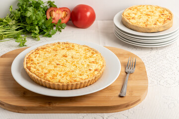 Cheese quiche, a pie on a wooden board, on a table