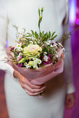 Woman hand holding flowers. Bouquet of flowers for congratulations.