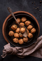 Meatballs in a frying pan on dark background