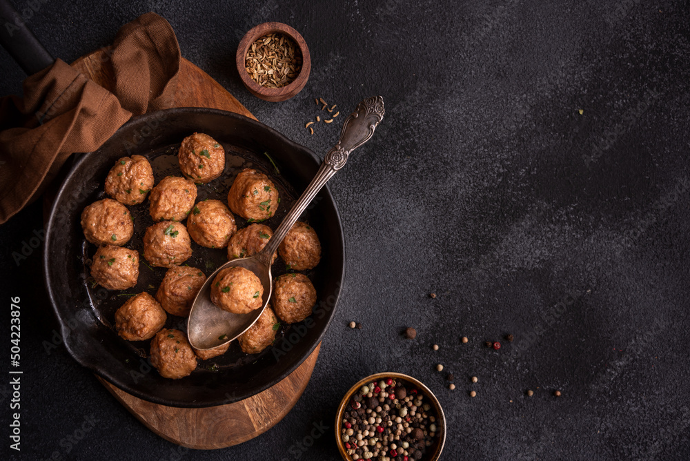 Wall mural meatballs in a frying pan on dark background