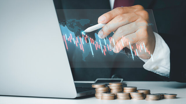 Planning and strategy, Stock market, Investment business Finance concept.Money management and Financial chart. The businessman is touching a growing virtual hologram stock and rows of coins.