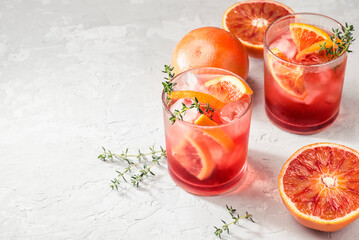 Red cocktail in base of Campari or bitter with  Sicilian red oranges (tarocco) on light gray...