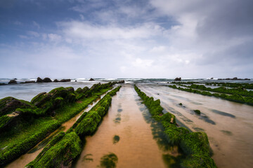 long exposure view of Flysch rock formations at low tide at Barrika beach near Bilbao