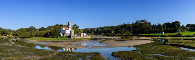 Fototapeta na wymiar panorama view of the Parish Church of our Lady of Sorrows in Barro on the Barro River at low tide