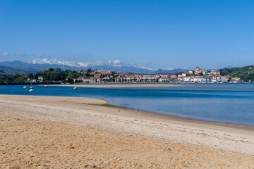 panorama view of Maza Beach and San Vicente de la Barquera with Picos de Europa mountains in the background