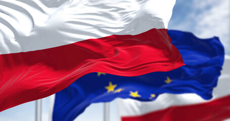 Detail of the national flag of Poland waving in the wind with blurred european union flag in the background
