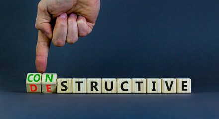 Destructive or constructive symbol. Businessman turns cubes and changes the concept word Destructive to Constructive. Beautiful grey background. Business constructive destructive concept. Copy space.