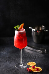 Drinks and beverages. A bright cocktail of raspberries and oranges in a transparent glass. Restaurant, bar. Background image, copy space