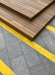 Urban geometric modern background with yellow lines on concrete tile and wooden construction.