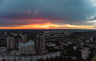 Epic vibrant sunset aerial view in city residential multistory district. 23 serpnia, Pavlovo Pole, Kharkiv, Ukraine. Fly at dusk, evening cloudscape and urban streets