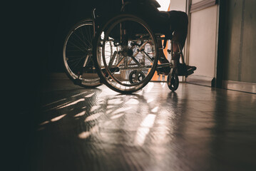 Naklejka na ściany i meble Wheelchair of person with disability in the house or hospital with nature sunlight, Cinematic tone and emotion picture, Life Insurance accident, International Day of Persons with Disabilities concept.