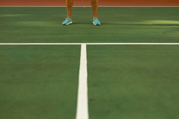 Low section of biracial senior man wearing blue sports shoes standing on tennis court