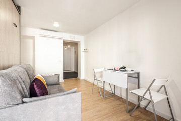 Study with folding dining table, side tables, furniture with folding sofa bed and balcony with wooden doors and shutters