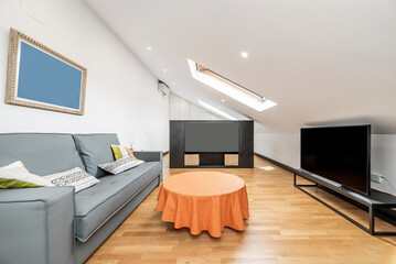 Apartment with sloping ceilings, unfolded sofa bed with checkered duvet, wooden floors and large...