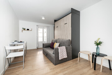 Study with folding dining table, side tables, furniture with folding sofa bed and balcony with wooden doors and shutters