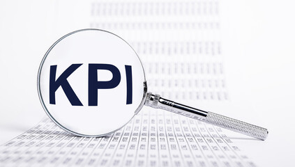Key performance indicators. Magnifier with KPI letters and documents with statistics. Analysis and measuring business effectiveness and progress in goals achievement. Strategic planning. photo