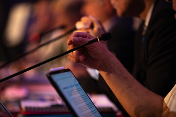 plusieurs personnes sont à la tribune lors d'un colloque, d'une convention ou d'une réunion...