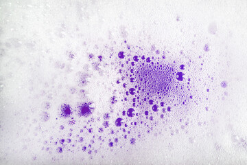 Texture of white foam bubbles on a bright purple background. Very Peri color 2022. Banner for shampoo, soap, detergents. Shampoo bubbles.