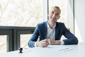 Handsome businessman signing a contract in an office Happy cheerful business person