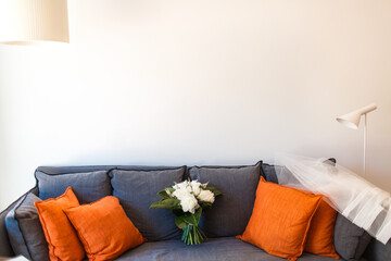 Beautiful wedding bouquet and pillows on the sofa