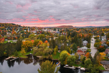 Beautiful town surrounded by hills covered in deciduous forest at the peak of autumn colours at...