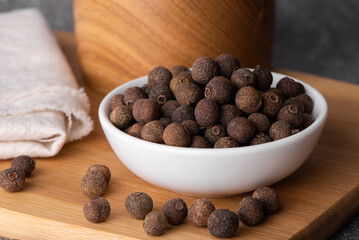 Pile of allspice isolated on white background. Jamaica pepper, allspice peppercorns or myrtle pepper in a bowl.