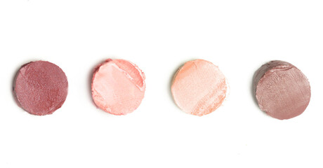 Set of creamy neutral toned makeup samples on white background	