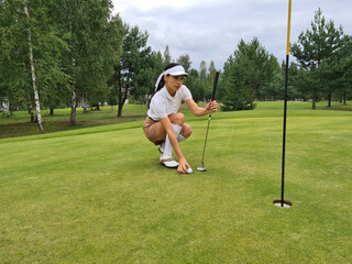 Obraz premium Golfer flattens ball on green before making hole