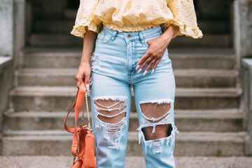 Obraz na płótnie Canvas Closeup female legs. Sexy woman in jeans with handbag. Fashion street outfit